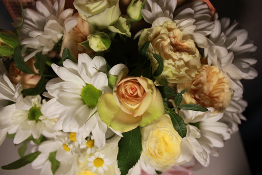 a bouquet of white and yellow flowers in a vase