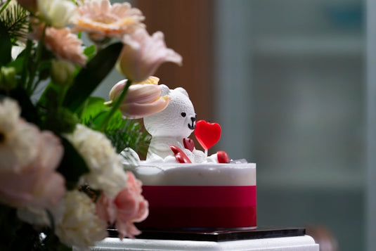 a white teddy bear sitting on top of a cake