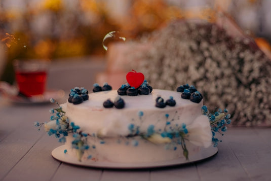 A white cake with blue berries on top of it